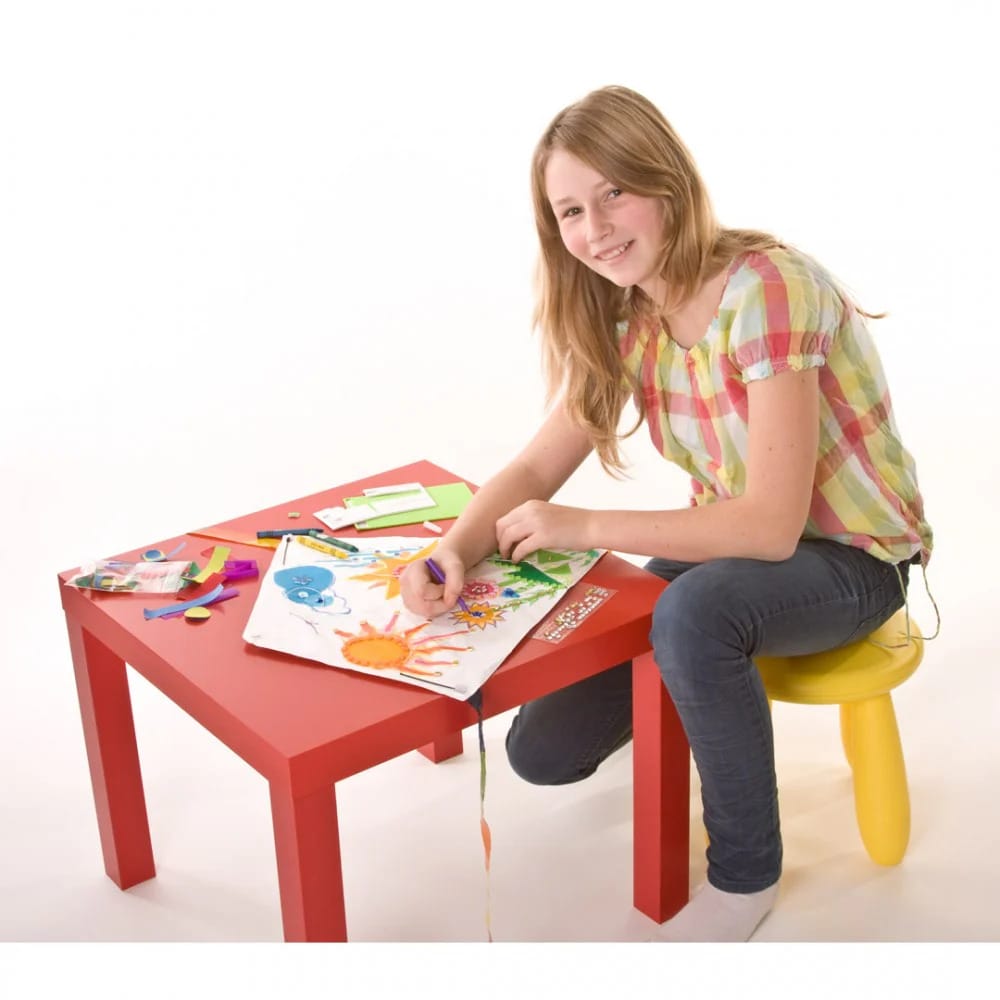 En pige sidder og tegner på en HQ Kids Creation Eddy. Dragen du kan tegne på, som holder dit motiv.