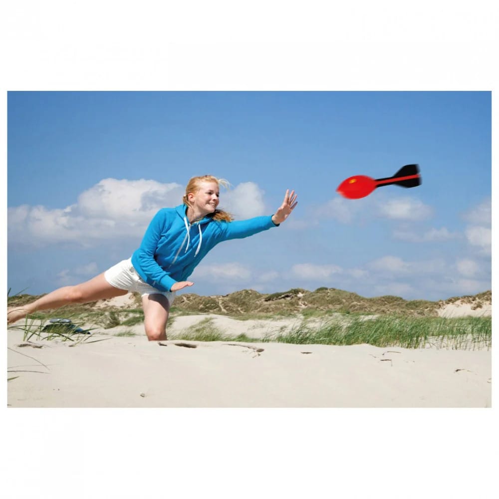 Kvinde leger med HQ Rocket XL Kastehyl på stranden