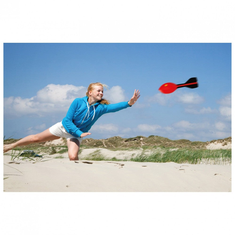 Kvinde leger med HQ Rocket XL Kastehyl på stranden