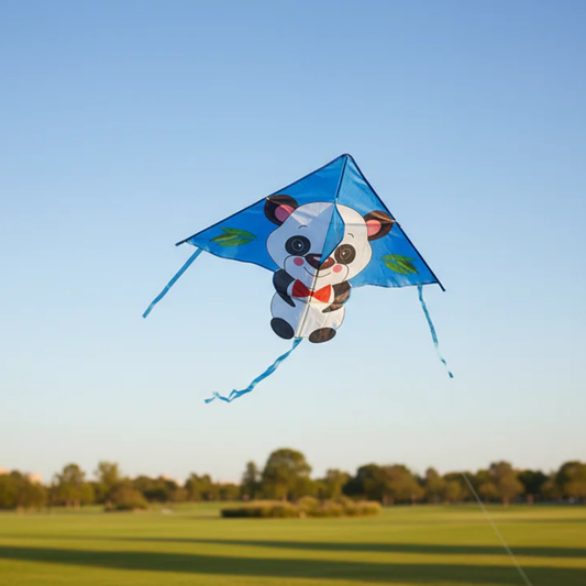 Wikz Panda Drage i sort og hvid, flyvende over mark mod blå himmel